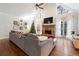 Bright living room with stone fireplace, cathedral ceiling, hardwood floors, and a comfortable gray sofa at 1701 Crowes Lake Ct, Lawrenceville, GA 30043