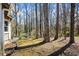 A wooded backyard with mature trees and landscaping, and a patio near the house at 6038 Maryjo Ln, Norcross, GA 30093
