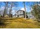 The exterior of the house sits on a rise overlooking a yard with trees and landscaping at 6038 Maryjo Ln, Norcross, GA 30093
