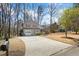 A charming two-story home with red shutters and a large driveway surrounded by beautiful trees and landscaping at 6038 Maryjo Ln, Norcross, GA 30093
