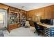 Cozy home office featuring wood paneled walls, built-in bookshelves, and neutral carpet at 6038 Maryjo Ln, Norcross, GA 30093