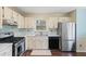 Bright kitchen with stainless steel appliances, double basin sink, and white cabinets at 6038 Maryjo Ln, Norcross, GA 30093