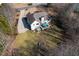 Aerial view of the home with a large backyard, patio set, and a fire pit at 6935 Autumn Hills Dr, Cumming, GA 30028
