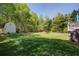 Expansive backyard featuring a shed, lush green lawn, and mature trees at 6935 Autumn Hills Dr, Cumming, GA 30028