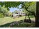 Spacious backyard featuring a deck, mature trees, fire pit, and decorative swing at 6935 Autumn Hills Dr, Cumming, GA 30028