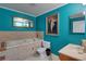 Elegant bathroom with a large soaking tub, teal walls, and a vanity area at 6935 Autumn Hills Dr, Cumming, GA 30028