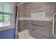 Modern shower with gray and white tiling, seat and accessible hand bar at 6935 Autumn Hills Dr, Cumming, GA 30028
