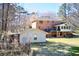 Expansive backyard with mature trees, a fire pit, and the home's exterior with a deck at 3970 Brenteresa Ct, Snellville, GA 30039