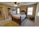 Spacious bedroom featuring a four-poster bed, carpeted floor, ceiling fan, and natural light from windows at 3970 Brenteresa Ct, Snellville, GA 30039