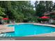 Inviting community pool surrounded by lounge chairs, tables with umbrellas, and lush greenery at 408 River Run Dr, Atlanta, GA 30350