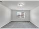 Empty bedroom with plush carpet, bright natural light from one window, and neutral-colored walls at 7104 Skippingstone Way, Douglasville, GA 30134