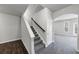Bright hallway with modern gray carpet, white staircase, and entry to the living room at 7104 Skippingstone Way, Douglasville, GA 30134