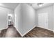 Hallway with dark wood floors, white trim and neutral paint at 7104 Skippingstone Way, Douglasville, GA 30134