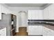 Modern kitchen featuring stainless steel refrigerator, white cabinets, and granite counters at 7104 Skippingstone Way, Douglasville, GA 30134