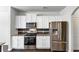 Bright kitchen featuring stainless steel appliances, white cabinets and granite countertops at 7104 Skippingstone Way, Douglasville, GA 30134