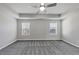 Bright main bedroom featuring two windows, plush carpet, and neutral paint at 7104 Skippingstone Way, Douglasville, GA 30134