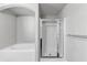 Modern bathroom featuring a combination bathtub and shower with sleek glass doors and contemporary fixtures at 7104 Skippingstone Way, Douglasville, GA 30134