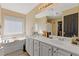 Bright bathroom with double vanity, soaker tub, and walk-in closet at 7382 Gossamer St, Union City, GA 30291