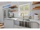 Close up view of the modern kitchen sink, faucet, and cabinet with natural light at 7382 Gossamer St, Union City, GA 30291