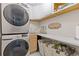 Functional laundry room with sink, storage, and stacked washer/dryer at 7382 Gossamer St, Union City, GA 30291