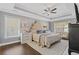 A spacious main bedroom featuring a tray ceiling, wood floors, and large windows at 7382 Gossamer St, Union City, GA 30291