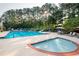 Resort-style community pool and hot tub surrounded by mature trees and comfortable lounge seating at 1026 Wellesley Crest Dr, Woodstock, GA 30189
