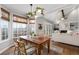Bright dining area with beautiful natural light, hardwood table, and view of an airy living area at 1026 Wellesley Crest Dr, Woodstock, GA 30189