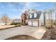 Long driveway leading to a brick home with a three-car garage and well-maintained landscaping at 1026 Wellesley Crest Dr, Woodstock, GA 30189