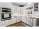 Gourmet kitchen with stainless steel appliances, sleek white cabinets, and hardwood floors at 1026 Wellesley Crest Dr, Woodstock, GA 30189