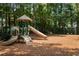 Enjoy the community playground featuring slides, a climbing structure, and swings, nestled among mature trees at 1026 Wellesley Crest Dr, Woodstock, GA 30189