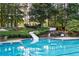 Fun pool area featuring a water slide, lounge chairs, and a gazebo in a wooded setting at 1026 Wellesley Crest Dr, Woodstock, GA 30189