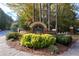 Community sign with brick base and manicured shrubs at 1026 Wellesley Crest Dr, Woodstock, GA 30189