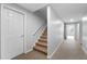 Carpeted staircase with a white door and trim in a neutrally painted home at 1026 Wellesley Crest Dr, Woodstock, GA 30189