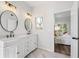 A bathroom with a white vanity, dual mirrors, and a view into the bedroom at 149 N Lakeside Nw Dr, Kennesaw, GA 30144