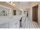 Elegant bathroom featuring a double vanity, a decorative mirror, and a tiled floor at 3410 Kates Way, Duluth, GA 30097