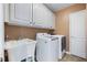 Functional laundry room with a utility sink, washer, dryer, and storage cabinets at 3410 Kates Way, Duluth, GA 30097