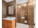 Cozy half bathroom featuring a vanity with a mirror, decorative light fixture and updated tile floors at 146 Crowell Se Rd, Conyers, GA 30094