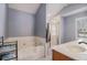 Bright bathroom featuring soaking tub, shower with glass door, and dual vanity with quartz countertops at 146 Crowell Se Rd, Conyers, GA 30094