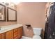 Powder room featuring a wood vanity, a single sink, and a toilet with a patterned shower curtain at 146 Crowell Se Rd, Conyers, GA 30094