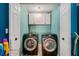 Closet laundry space with dual front-loading washers and dryer, cabinets, and shelving for convenient storage at 146 Crowell Se Rd, Conyers, GA 30094