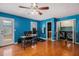 Bright living room with hardwood floors, blue accent wall, ceiling fan, and laundry closet with washer and dryer at 146 Crowell Se Rd, Conyers, GA 30094