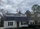 Quaint one-story home with a unique architectural design and dark shutters on a cloudy day at 1867 Dresden Dr, Atlanta, GA 30319