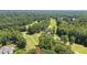 Aerial view of the lush landscape, nestled amongst mature trees with the greens of a nearby golf course at 2287 Lake Ridge Ter, Lawrenceville, GA 30043