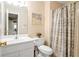 This bathroom features a toilet, vanity, mirror and shower with curtain at 2287 Lake Ridge Ter, Lawrenceville, GA 30043