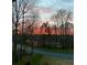 Scenic street view with mature trees capturing a serene sunrise, offering a tranquil glimpse of neighborhood living at 2287 Lake Ridge Ter, Lawrenceville, GA 30043
