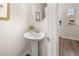 Well-lit half bathroom with a modern pedestal sink and wood-look flooring at 9472 Cedar Grove Ct # 237, Jonesboro, GA 30238