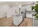 Bright kitchen featuring an island with a sink, stainless steel fridge, and hardwood floors at 9472 Cedar Grove Ct # 237, Jonesboro, GA 30238