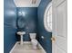 Cozy half bathroom features a pedestal sink, an oval window and modern fixtures at 4526 Balto Way, Acworth, GA 30101