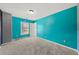 Bright bedroom with teal walls, plush carpet, and natural light from the window at 4526 Balto Way, Acworth, GA 30101