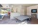 Community recreation room with ping pong table and an adjacent lounge area with a fireplace at 4561 Olde Perimeter Way # 2609, Atlanta, GA 30346